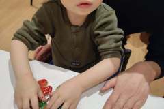 Chłopiec kładzie dłonie na talerzyk z piernikami.