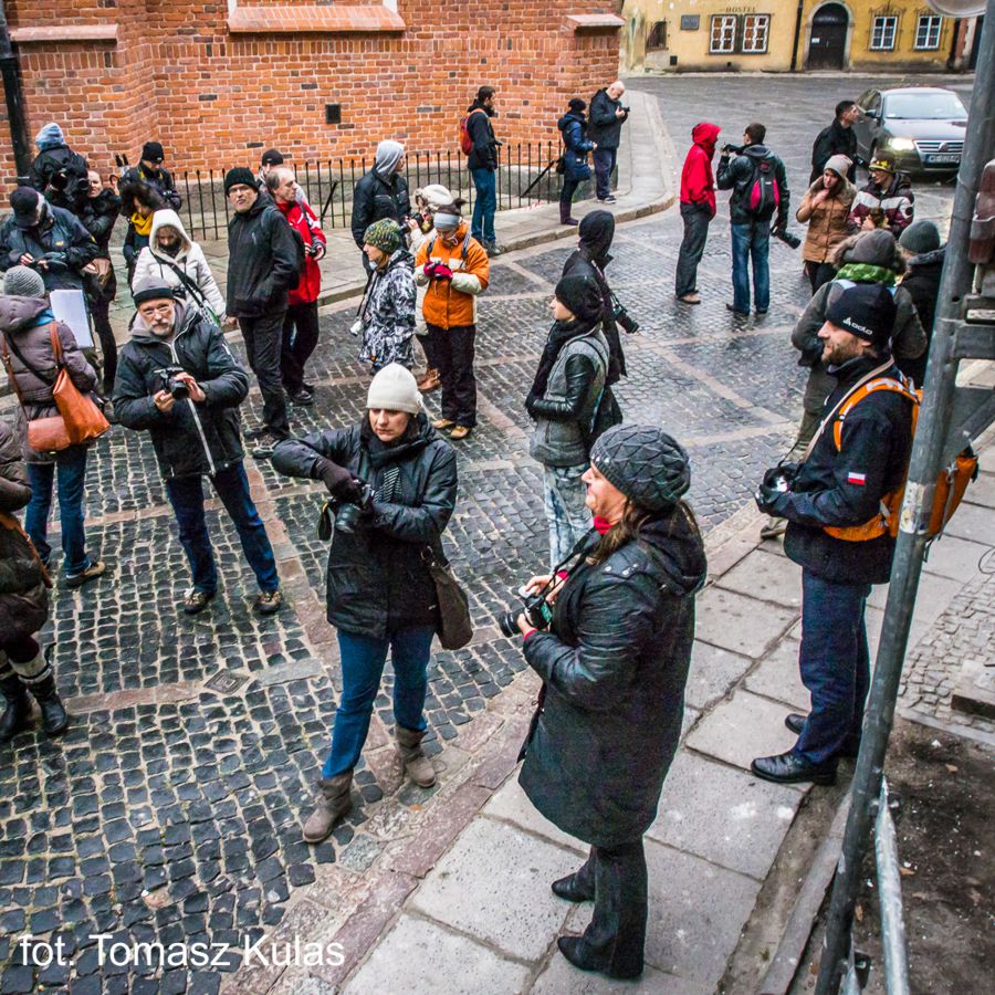 Na zdjęciu grupa ludzi na ulicy robiących zdjęcia