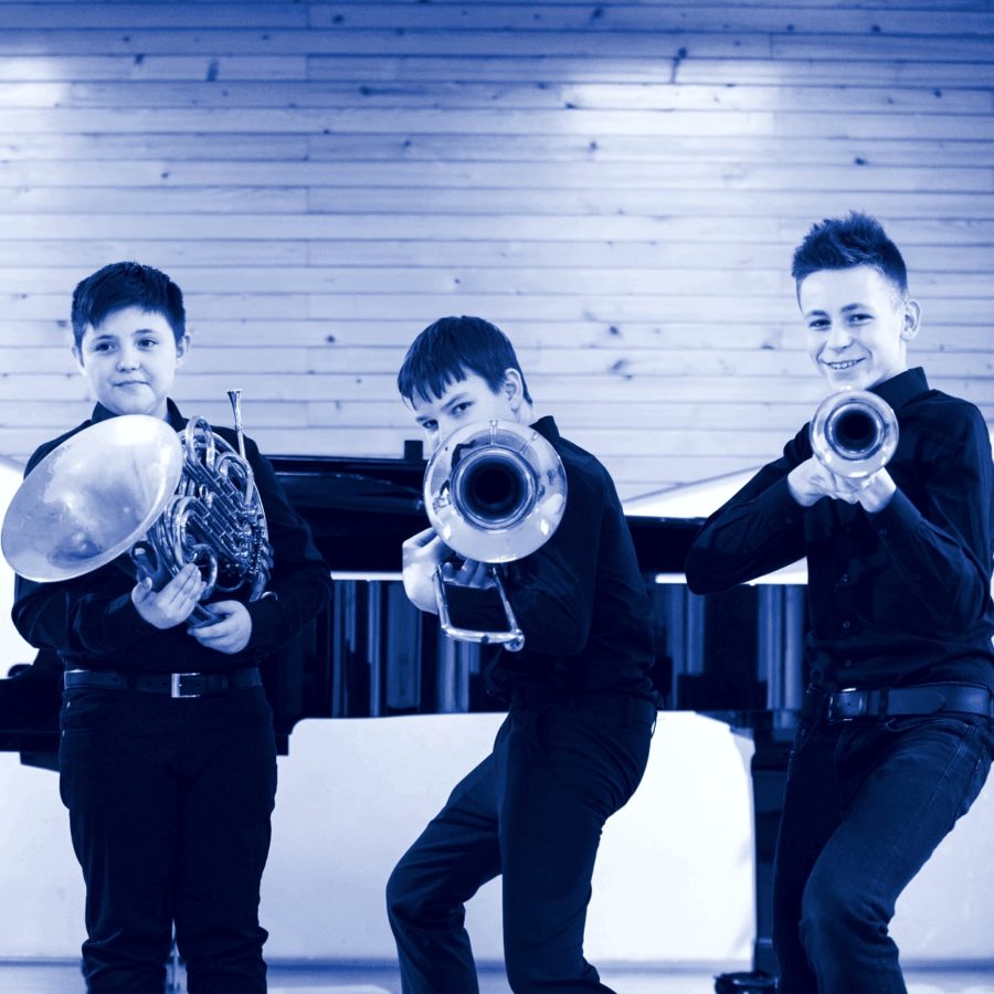 trzech chłopców z instrumentami dętymi